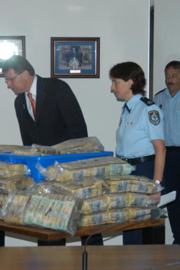 Cash haul ... police examine one of the syndicate's hoards of money found in numerous raids.