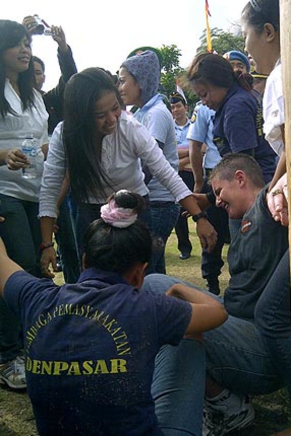 Bali Nine inmate Renae Lawrence anchors a human tower in the traditional game of Panjat Pinang during Independence day festivities at Bali's Kerobokan prison this morning.