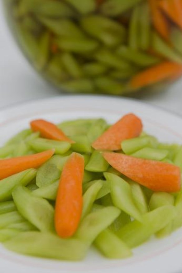 Delicious: A jar of homemade pickle with asparagus lettuce stems; and a plate of carrots and pickles.