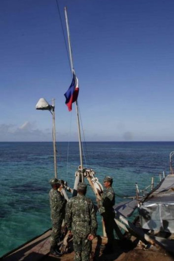 Philippines Marines salute their country's flag after the changing of the guard on board the Sierra Madre.