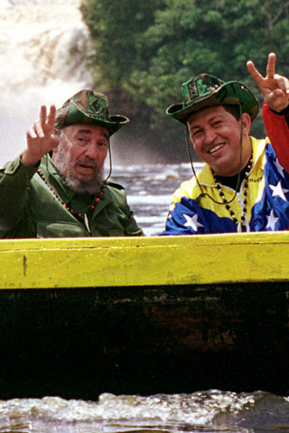 Cuba's President Fidel Castro, left, and Venezuela's President Hugo Chavez wave to a crowd while touring Canaima National Park in eastern Venezuela in a canoe.