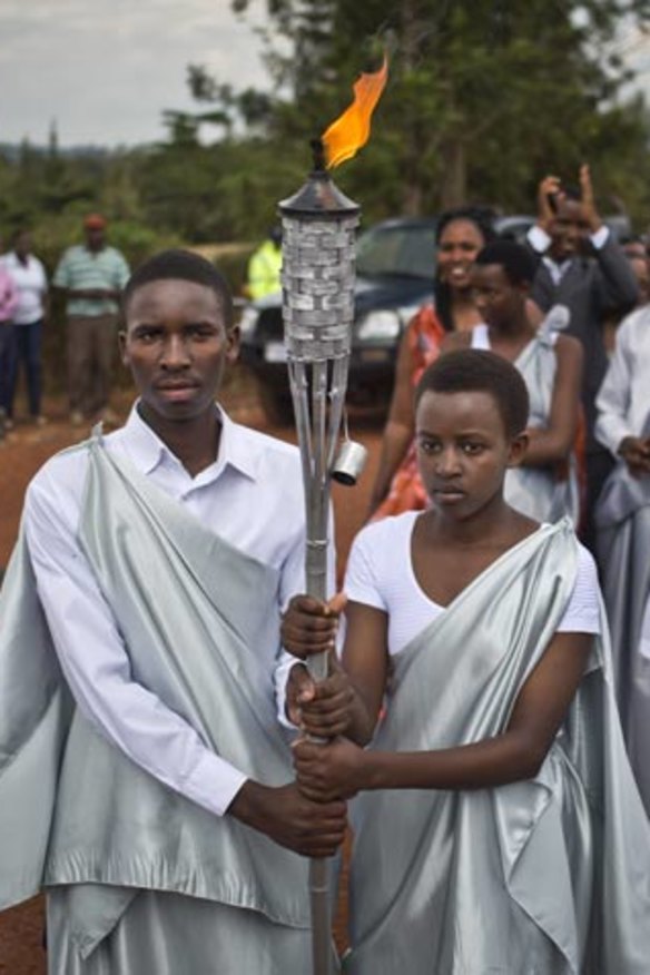 Youths carry a flame of remembrance to a ceremony last week where villagers from surrounding areas gathered to hear genocide memories, in the town of Kirehe, eastern Rwanda.