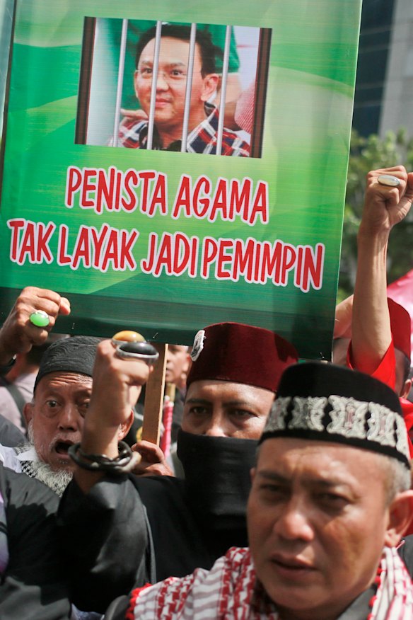 Muslims protesters hold up a poster depicting Jakarta Governor 'Ahok' behind bars. 