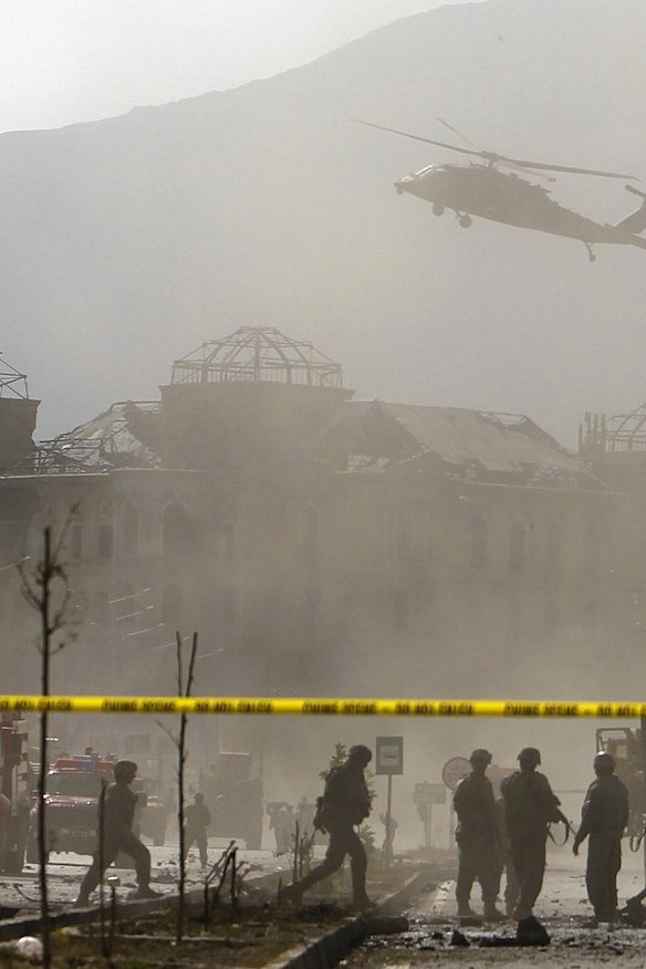 A NATO helicopter flies over the site of a bomb blast in Kabul.