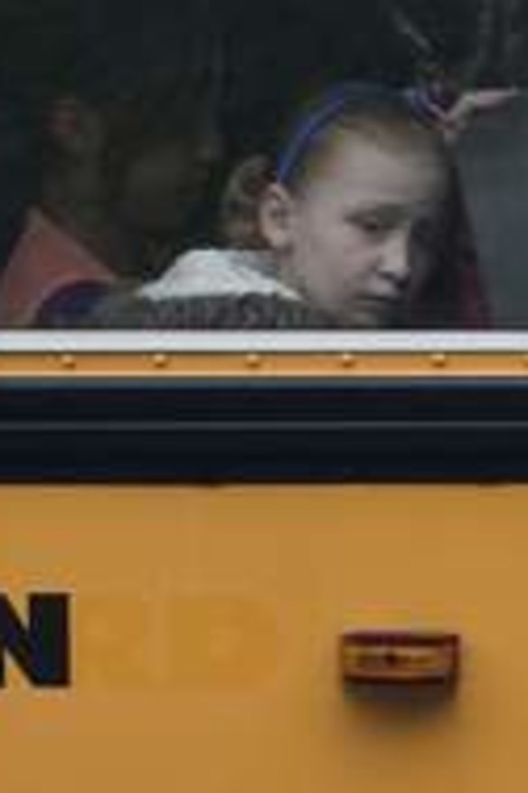 Children sit on a bus adorned with a quote from slain Sandy Hook school principal Dawn Hochsprung.