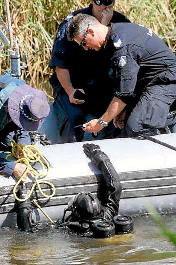 A police diver hands over an object found in a search of the Yarra River in March related to Dimitrios Belias' death.