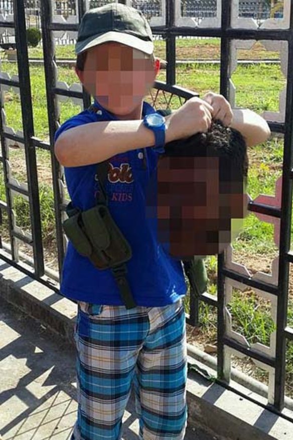 A boy believed to be Australian Khaled Sharrouf's son holds the decapitated head of a soldier.