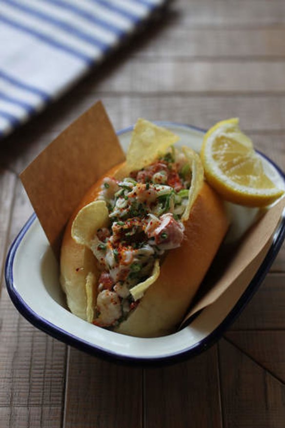 A mini lobster roll with celery, lemon and mayo.
