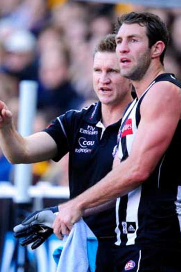 Collingwood coach Nathan Buckley gives Travis Cloke instructions during the game.
