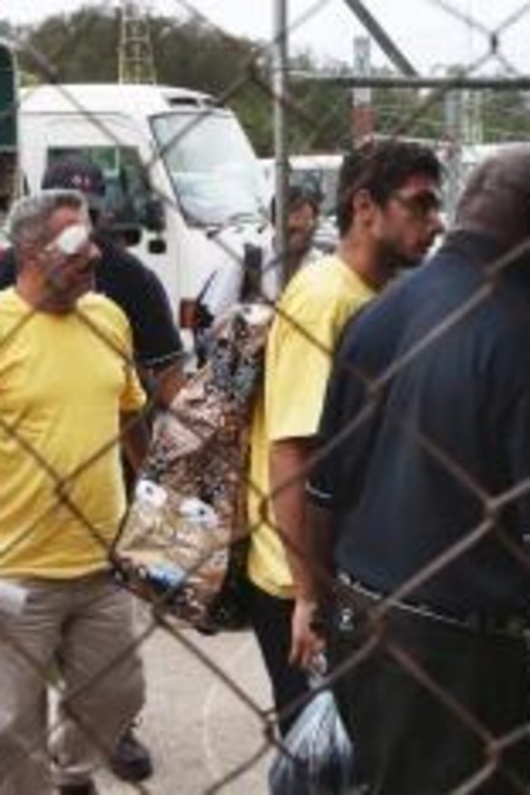 Two asylum seekers, one with an eye injury, leave Manus Island airport following the detention centre violence in which Reza Barati was killed earlier this year.