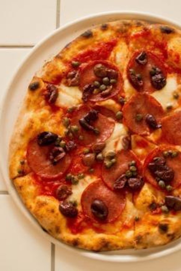 Pizza scattered with olives and capers.