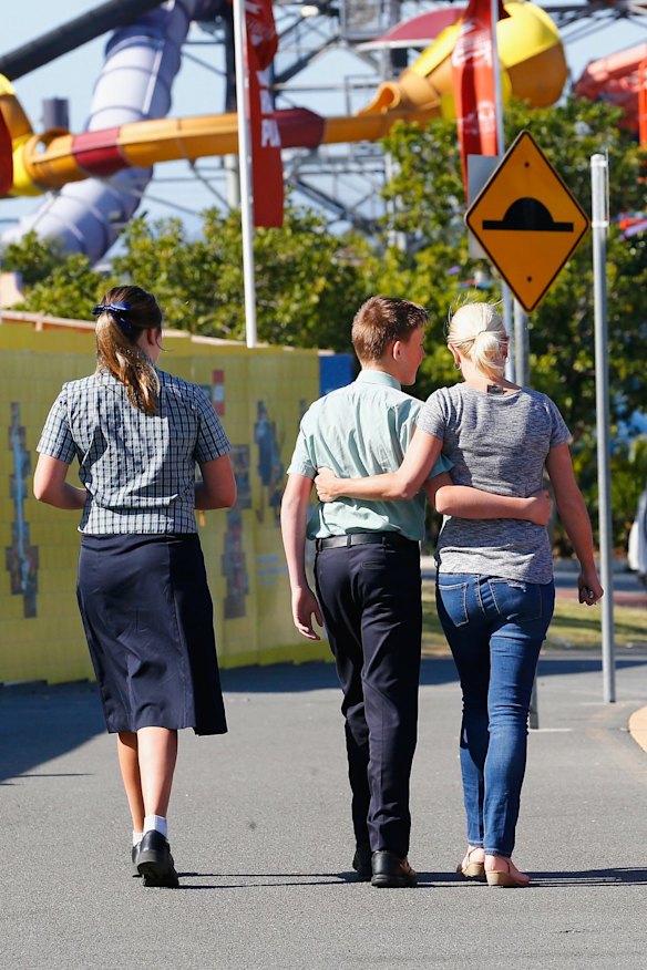 Residents embrace after laying flowers at the theme park.