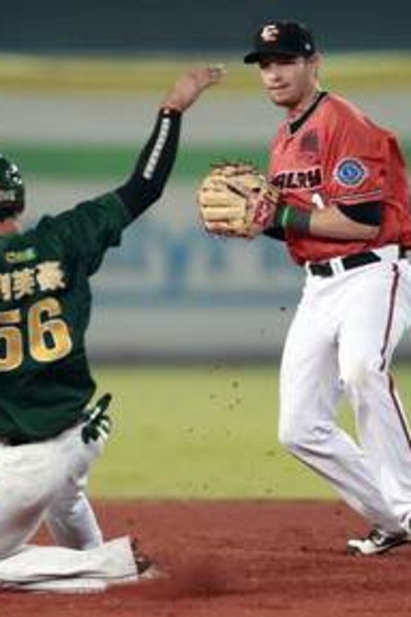 Base runner Liu Fu-hao (56) of Taiwan's Uni-President 7-Eleven Lions slides to second base while Shane Opitz of Australia's Canberra Cavalry waits during the third inning of the final of the Asia Series at Taichung Intercontinental Baseball Stadium November 20, 2013.