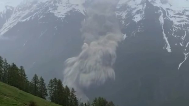 Video shows a huge mudslide near Blatten, with homes and buildings partially submerged under a mass of brownish sludge.