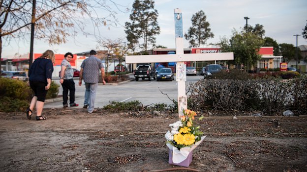 A cross outside the Hungry Jack’s car park in southwest Sydney marks the spot where police shot Courtney Topic.