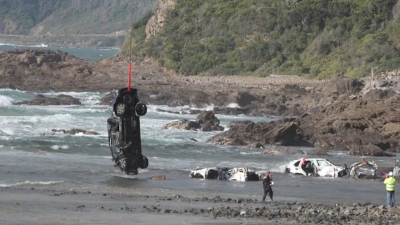 Mangled cars winched by helicopter as flood clean-up continues