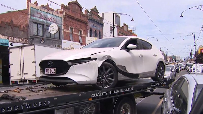Man restrained by passersby after car crashes on busy road