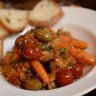 Braised rabbit with cherry tomatoes, carrots and olives.