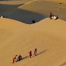 Residents walk on sand dunes in the Libyan desert oasis town of Ghadames