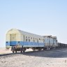 A passenger carriage brings up the rear of the immensely long freight train.