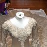 Specialist Textile Installer, Keira Millar from the Victorian and Albert Museum inspects a dress at the Bendigo Art Gallery Wedding Dress Exhibition 