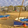 Strange cloud formation in the early morning with small Cornish fishing boats at low tide in the harbour at St. Ives, Cornwall, England.