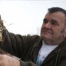 A Serbian villager hangs a garlic braid, used as vampire repellant, on a window on December 3, 2012 in the western Serbian village of Zarozje.