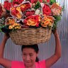 In bloom ... a woman carries a basket of flowers for sale in San Salvador, the capital of El Salvador.