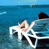 WOMAN LYING ON BEACH CHAIr.