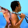 Belize, fisherman with catch slung over shoulder. 