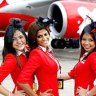 Flight attendants pose in front of an AirAsia X A340 passenger jet.