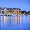 The lights of the grand architecture along the Inner Harbour are reflected in the water. 