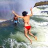 Woman jumping into Devil's Pool at Victoria Falls, Zambia, Africa